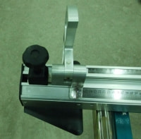 Телескопическая линейка опорного стола скомплектована двумя передвижными откидными упорами снабжённых линзами для удобства точного выставления размеров.